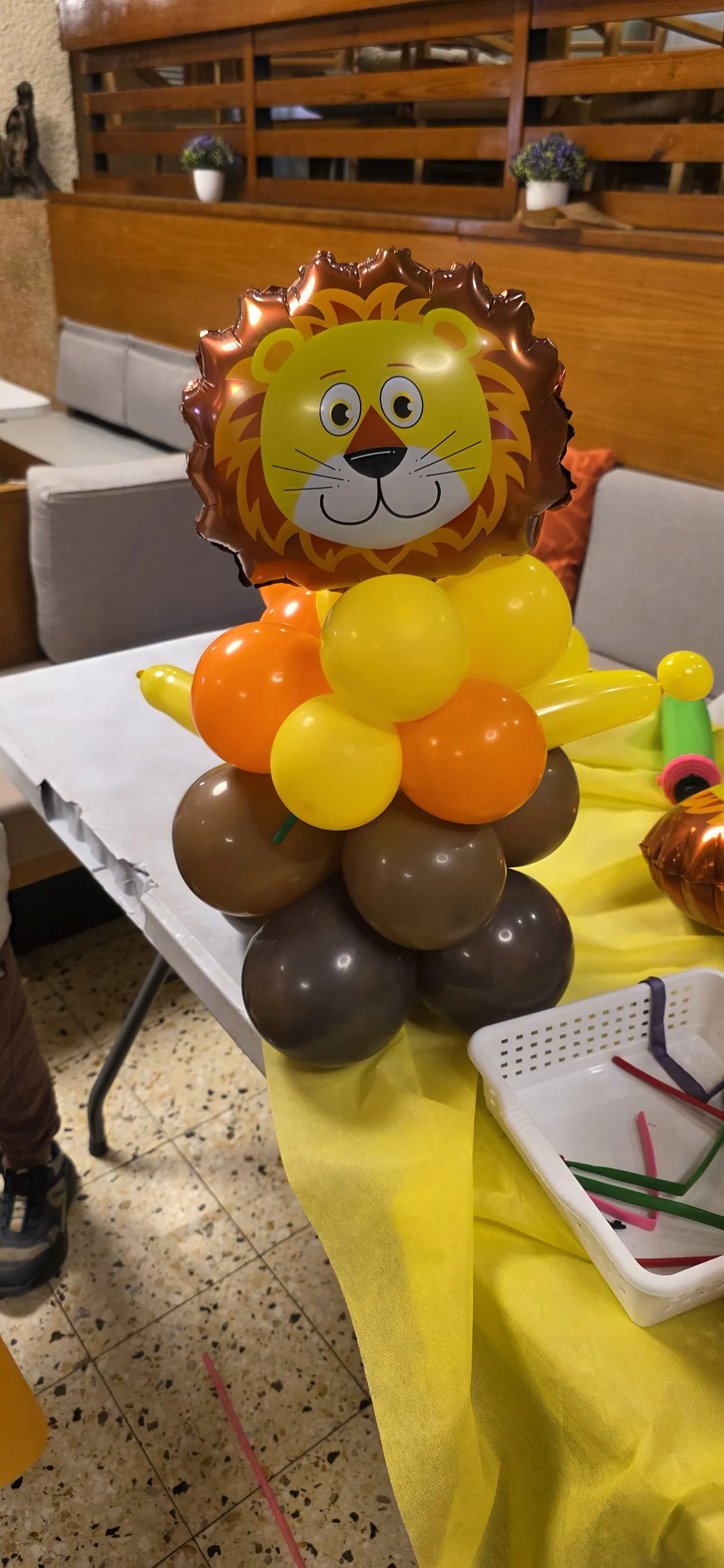 עמוד בלונים עם ראש אריה בגוונים כתום, צהוב וחום