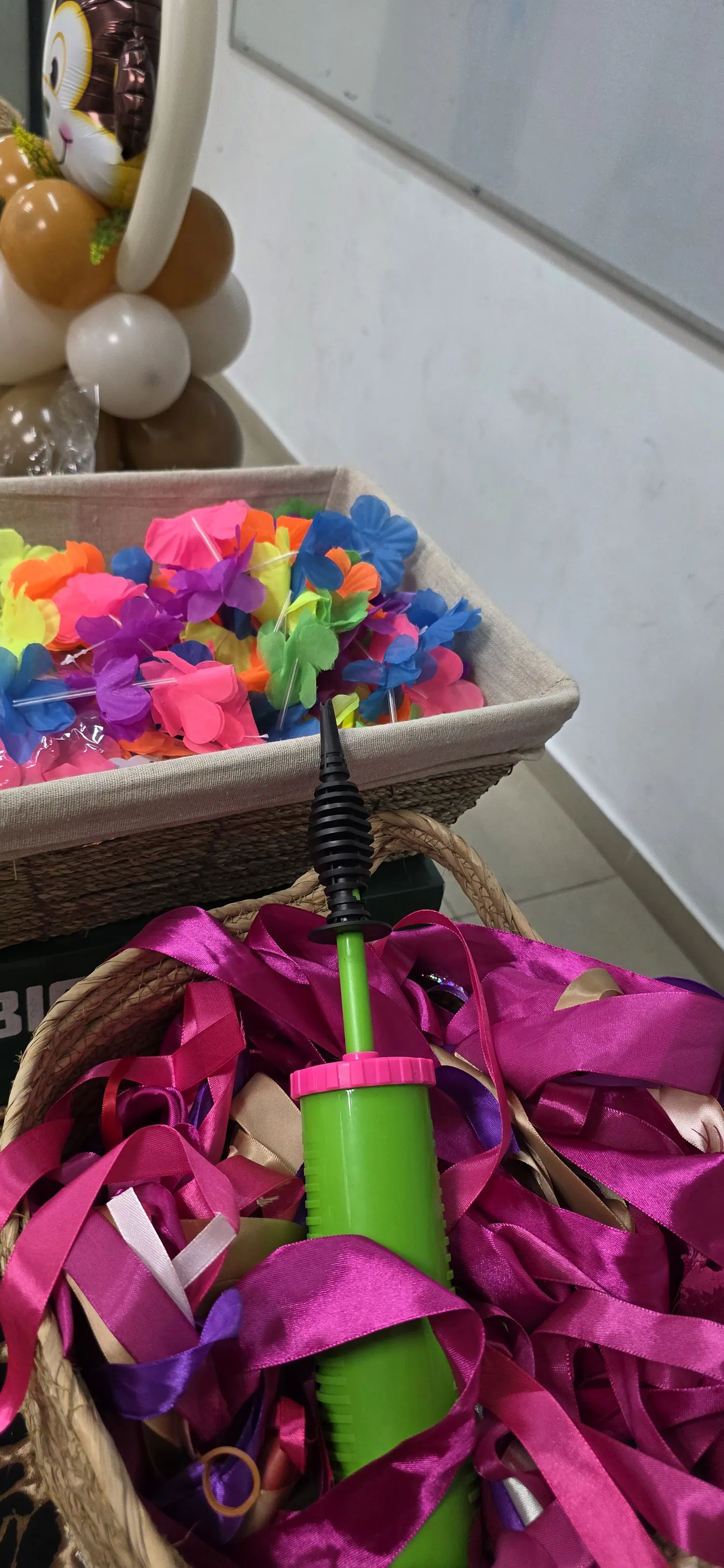 סל מלא בפרחי בלונים צבעוניים ומשאבת ניפוח