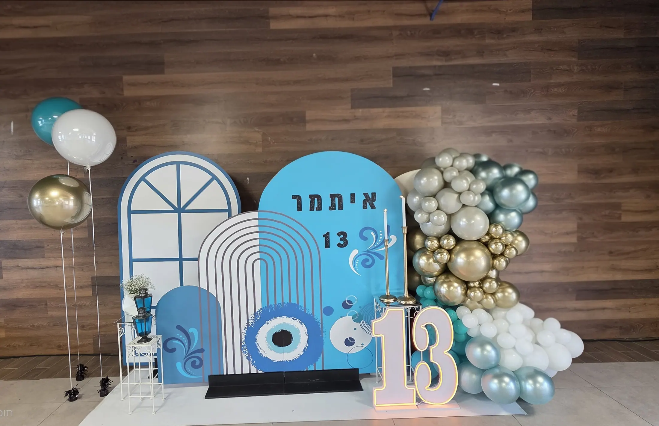 רקע למספר 13 עם קשת בלונים טורקיז וזהב ועיטור עין