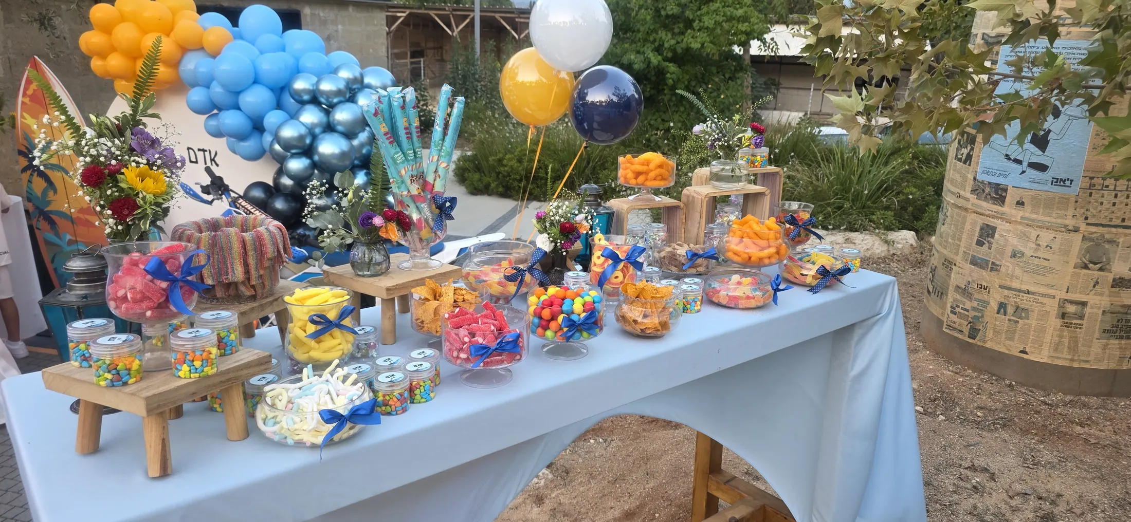 שולחן מתוקים חיצוני בגווני כחול וכתום עם בלוני קישוט