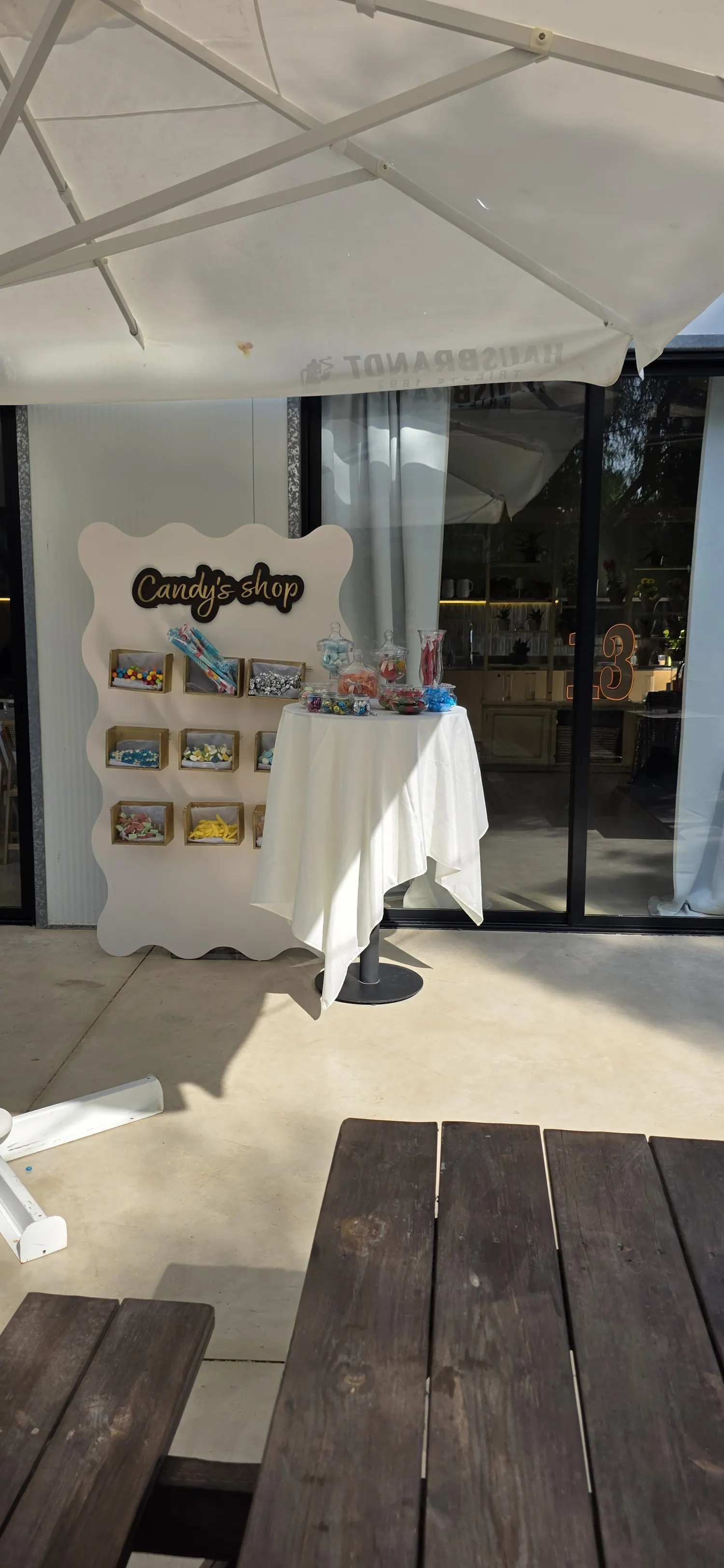 עמדת Candy's Shop לבנה עם קופסאות ממתקים אישיות בחוץ