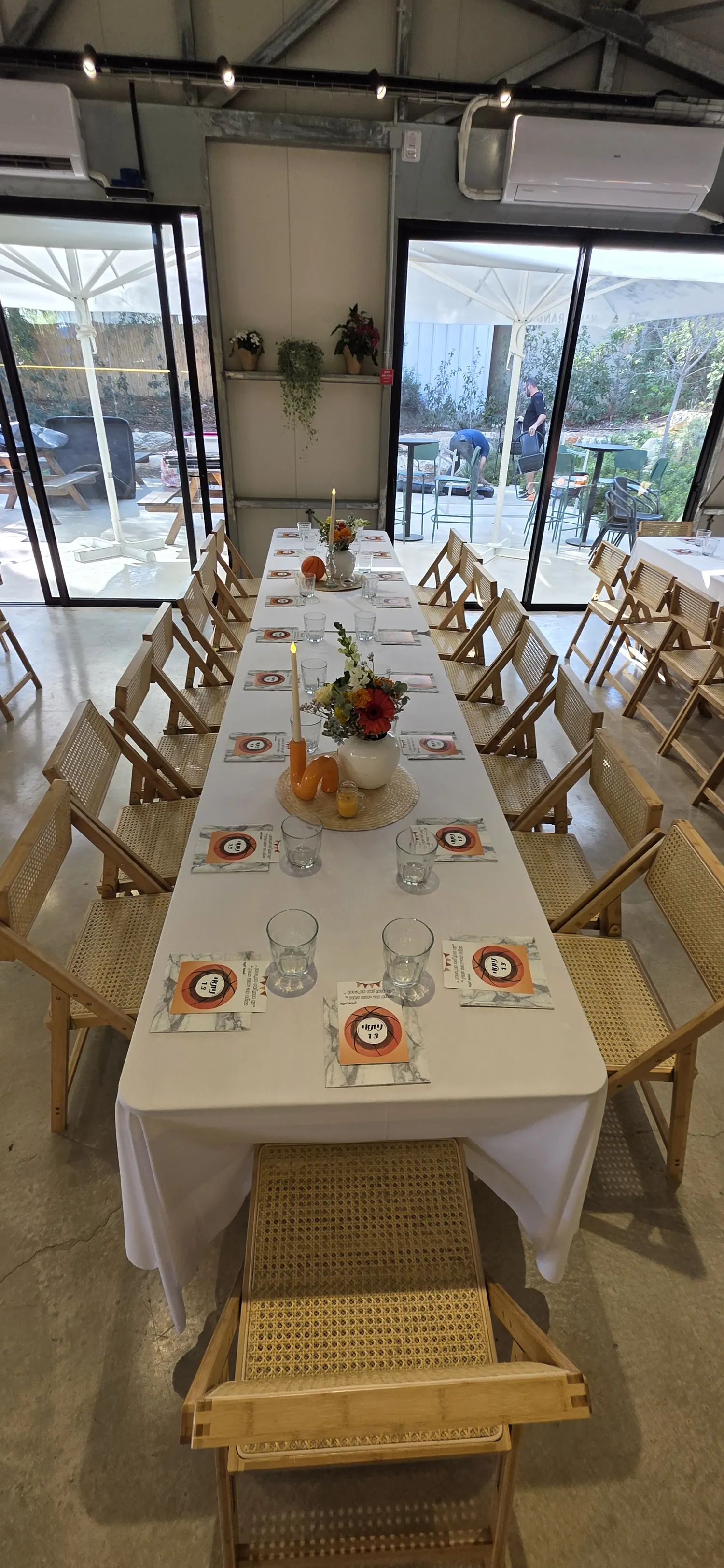 שולחן ארוך עם כיסאות עץ ותפריט אישי לכל סועד